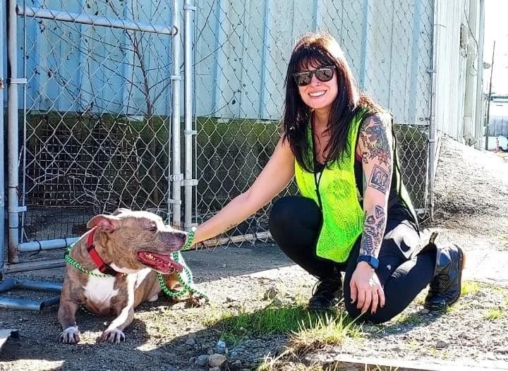 Erica volunteering at Villalobos Rescue Center with a smiling pit bull